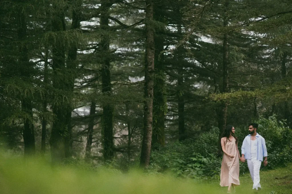 Couple walking hand in hand through a peaceful pine forest with natural scenery and soft daylight