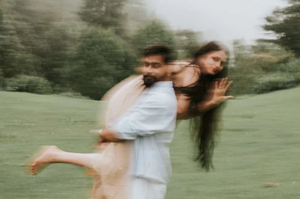 Playful couple sharing a joyful moment outdoors with creative motion blur during a romantic photoshoot