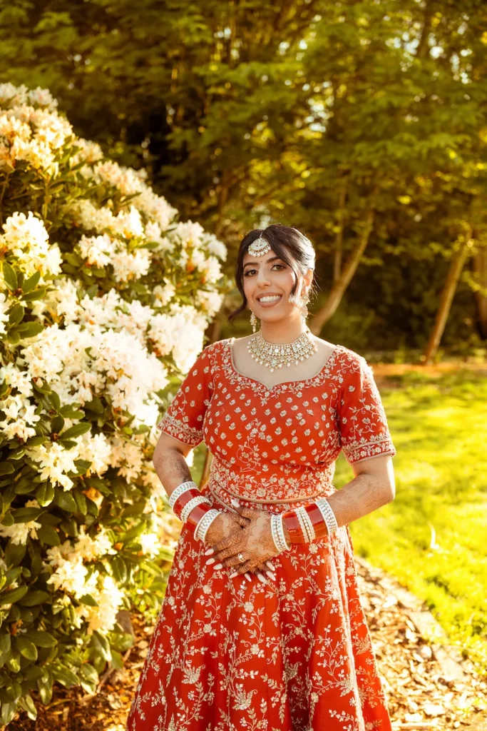 Elegant Punjabi wedding in Rishikesh bridal portrait surrounded by blooming flowers and natural greenery