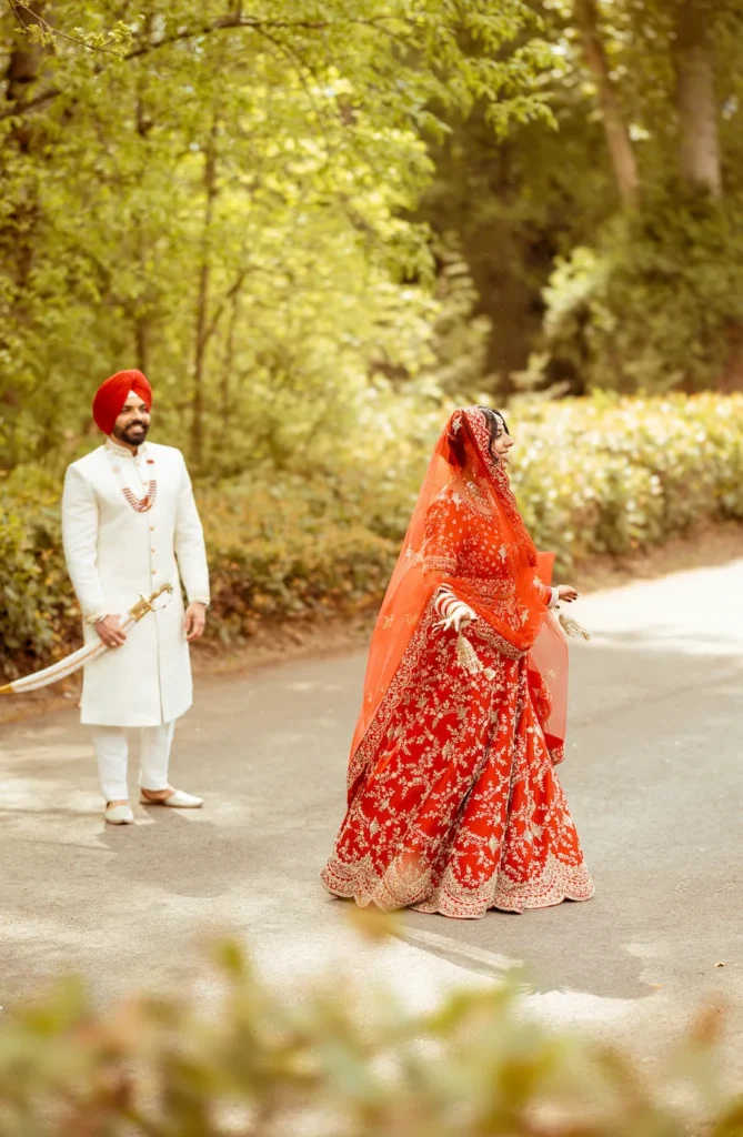 Punjabi wedding in Rishikesh candid bridal moment with groom watching during an outdoor wedding photoshoot