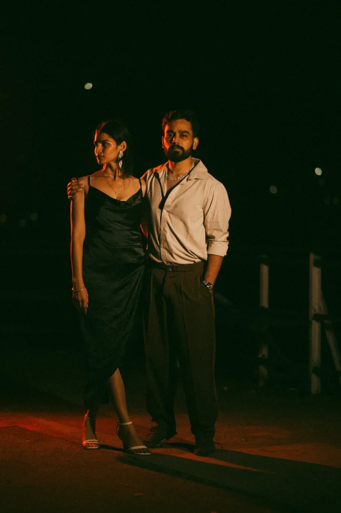 Stylish evening portrait of a couple standing together under cinematic lighting during a romantic photoshoot