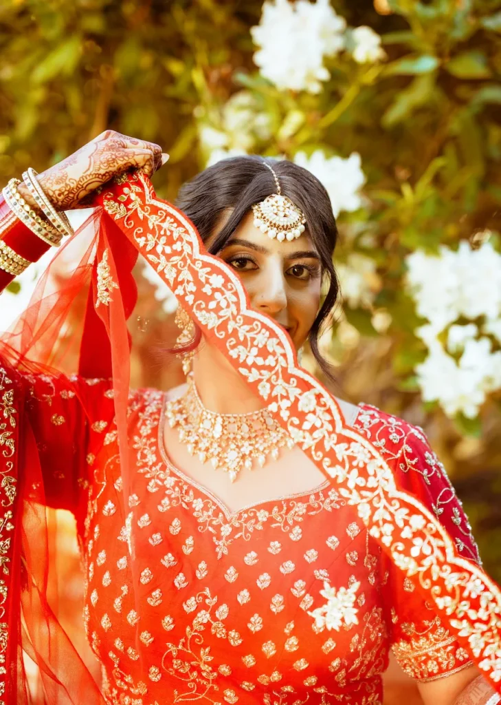 Elegant bridal portrait from a Punjabi wedding in Rishikesh showcasing traditional red bridal attire and jewelry