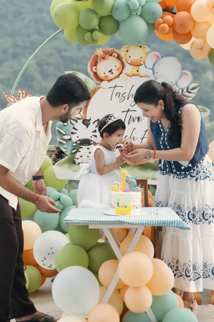 Parents celebrating their daughter's birthday together during a joyful cake-cutting ceremony.