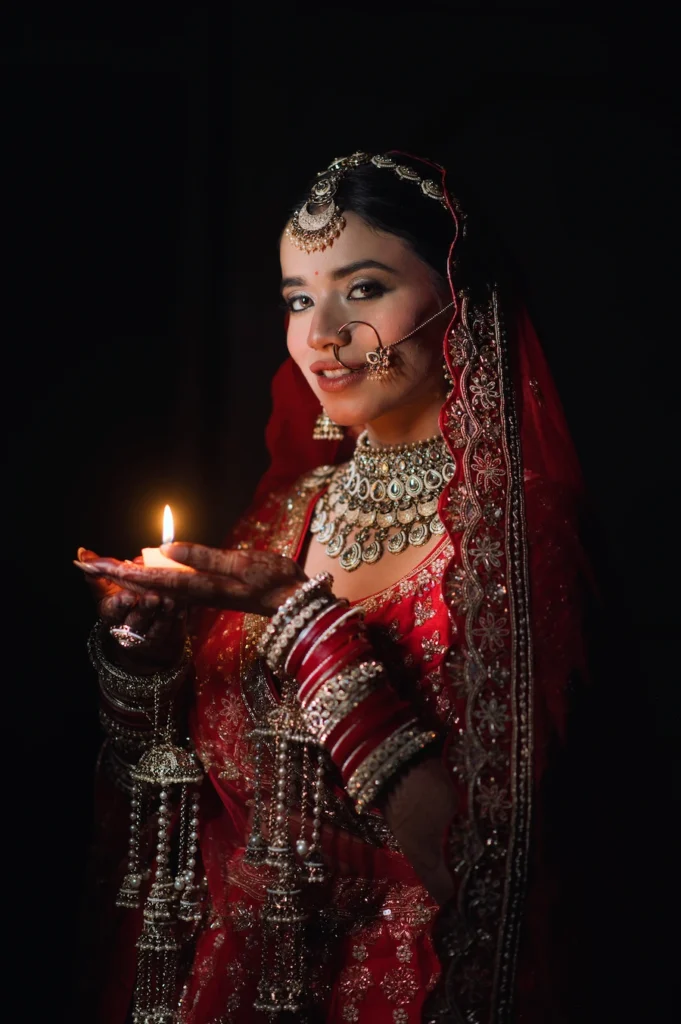 Bride holding a traditional diya during an intimate wedding ritual captured in low light