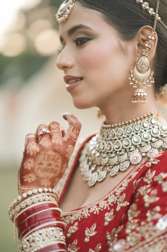 Close-up bridal portrait showcasing traditional jewelry, intricate mehndi, and elegant wedding styling