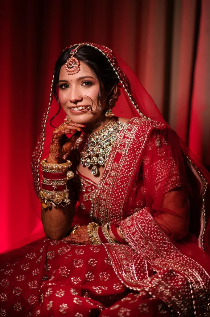 Traditional bridal portrait highlighting intricate jewelry, bridal makeup, and red wedding attire