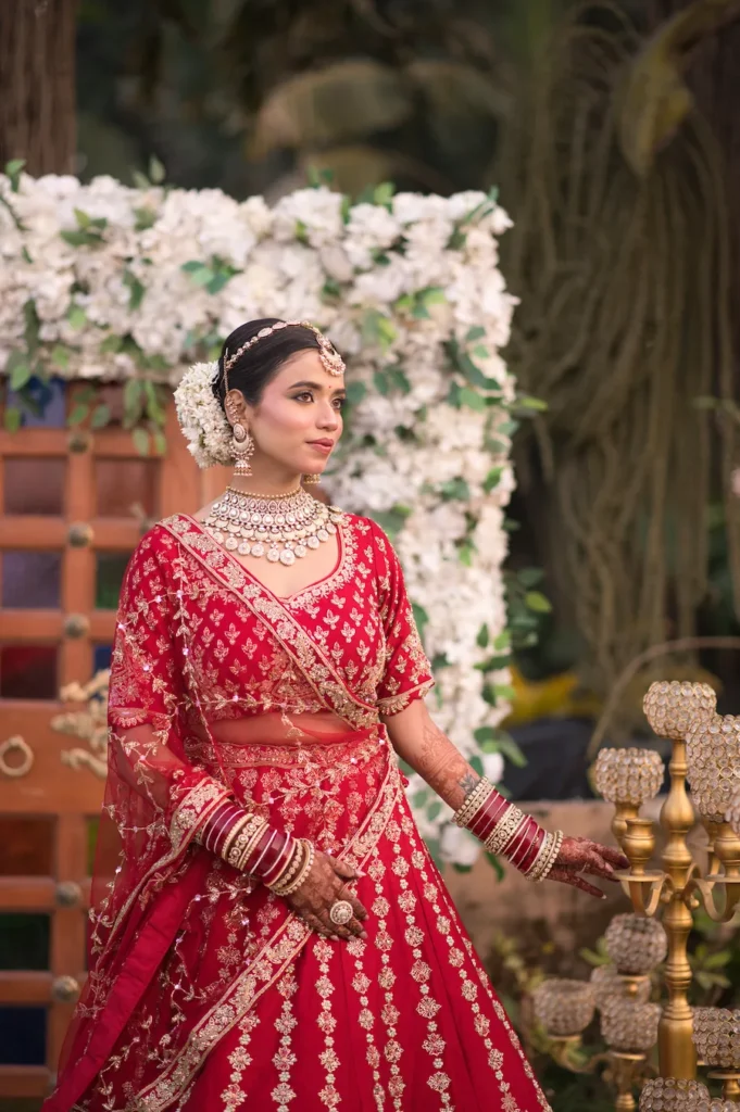 Bride posing gracefully beside floral décor before the wedding ceremony.
