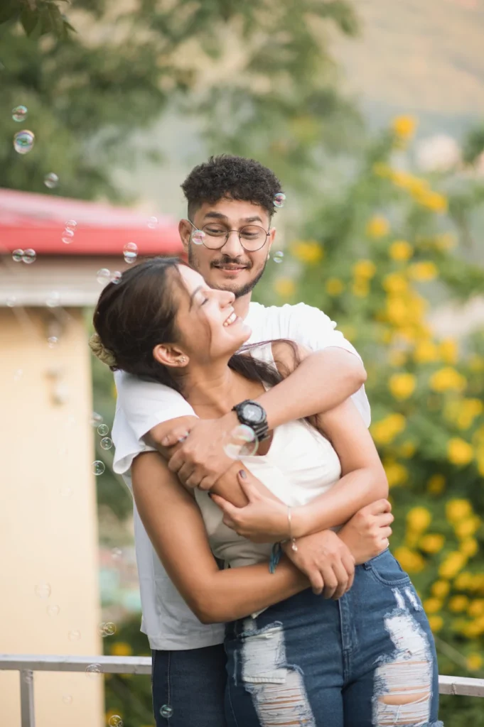 Best Pre Wedding Photographer in Dehradun capturing a joyful couple portrait with natural smiles and playful bubbles during an outdoor photoshoot.