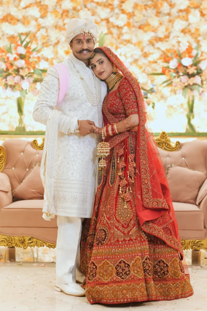 Newlywed couple posing together on the wedding stage with elegant floral decorations.