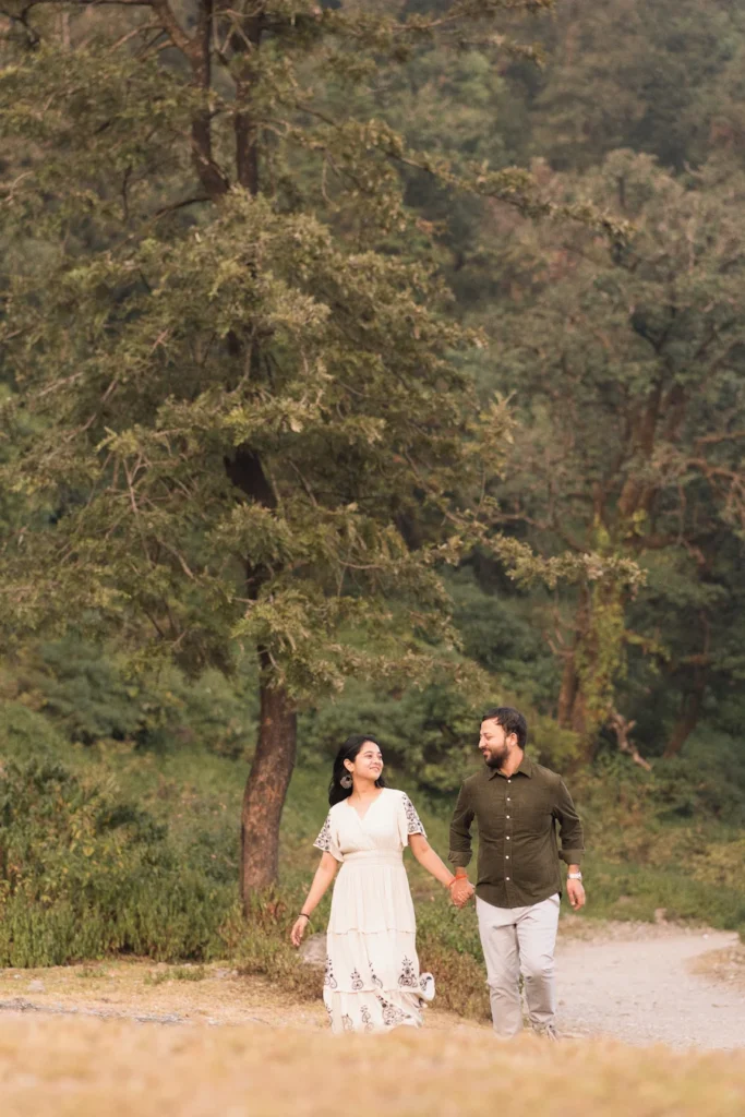 Professional Pre Wedding Photographer in Dehradun documenting a couple walking hand in hand through a scenic forest trail.