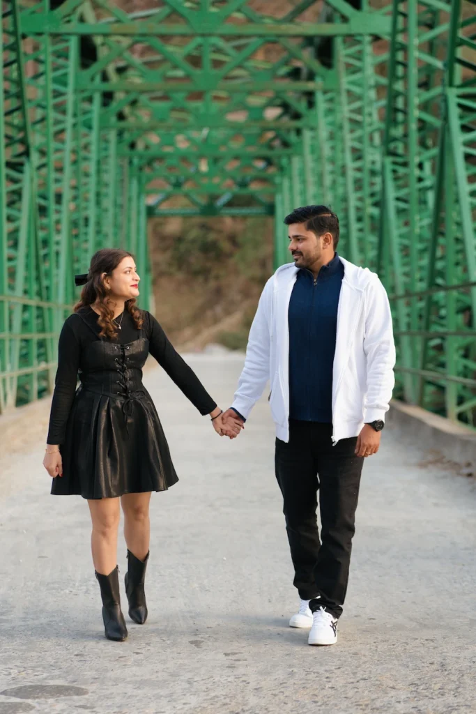 Couple walking hand in hand on a scenic bridge in Uttarakhand