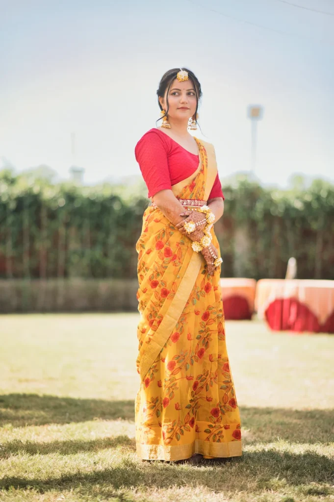 Traditional portrait of a woman in a yellow saree during a pre-wedding celebration