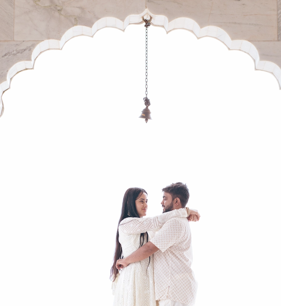 Traditional Pahadi Pre-Wedding couple sharing a romantic moment beneath a temple bell in Mussoorie
