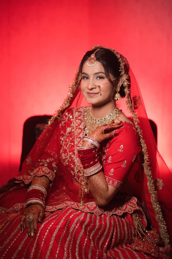 Classic bridal portrait with traditional attire, jewelry, and elegant red backdrop