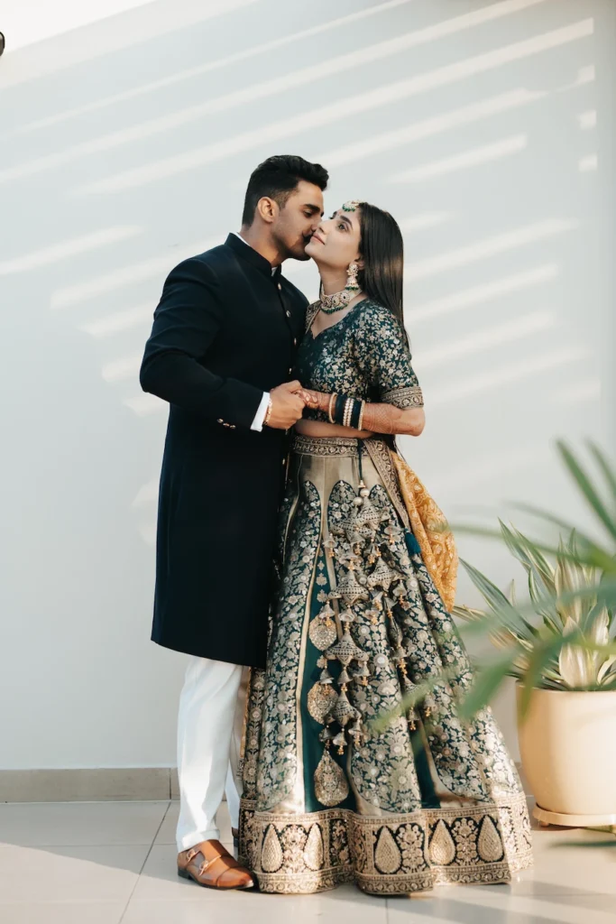 Couple sharing a romantic embrace in elegant traditional outfits before the reception.