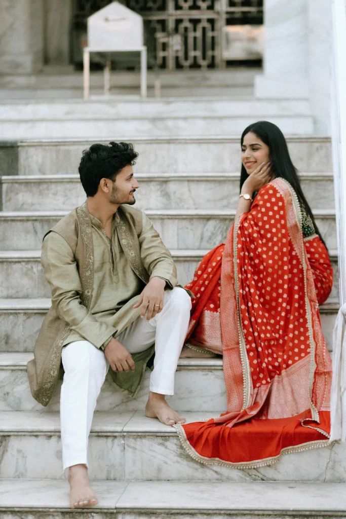 Traditional Pahadi Pre-Wedding couple sharing a candid moment on temple steps in Uttarakhand