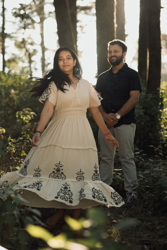 Candid pre wedding photoshoot in a pine forest near Mussoorie with a couple enjoying a natural and cinematic moment.