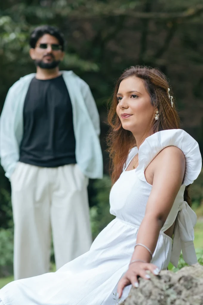 Candid portrait of the bride-to-be with her partner softly blurred in the background.