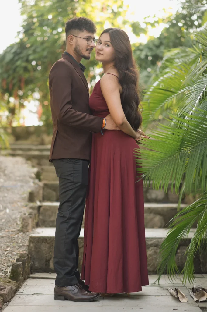 Elegant couple portrait surrounded by lush greenery, capturing love and connection in a beautiful outdoor setting.