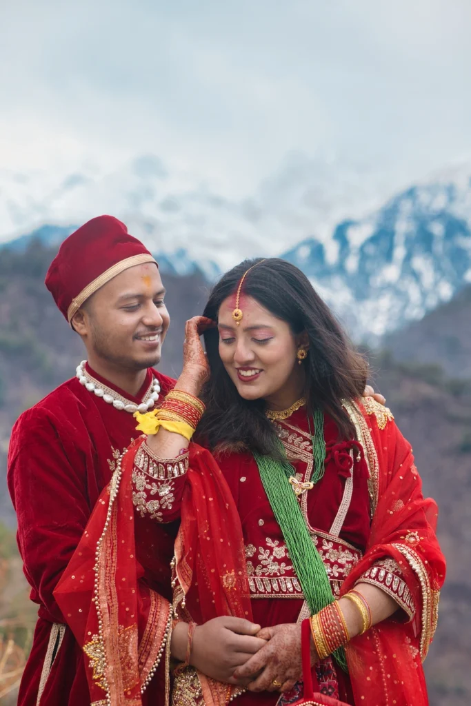 Bride and groom sharing a romantic moment with snow-covered mountains in the background.