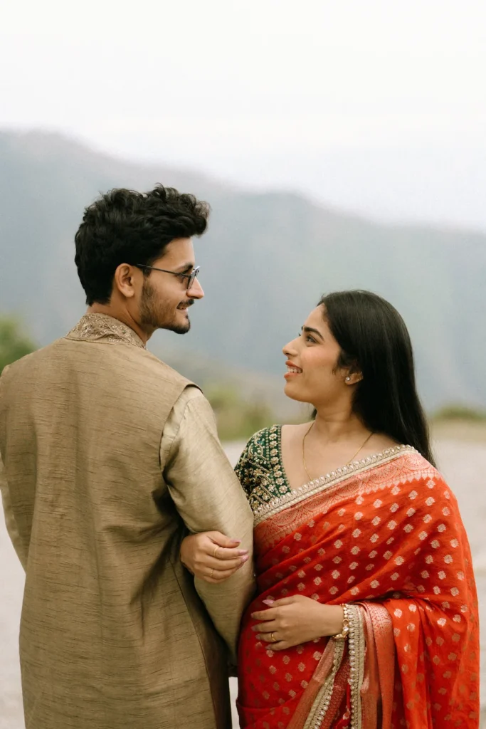 Traditional Pahadi Pre-Wedding couple enjoying a candid moment against a scenic mountain backdrop