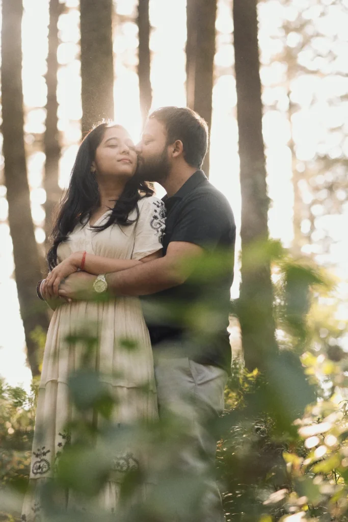 Professional Pre Wedding Photographer in Dehradun capturing a romantic couple embracing in a pine forest during golden hour.