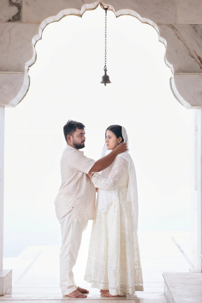 Traditional Pahadi Pre-Wedding portrait capturing romance beneath a Himalayan temple arch