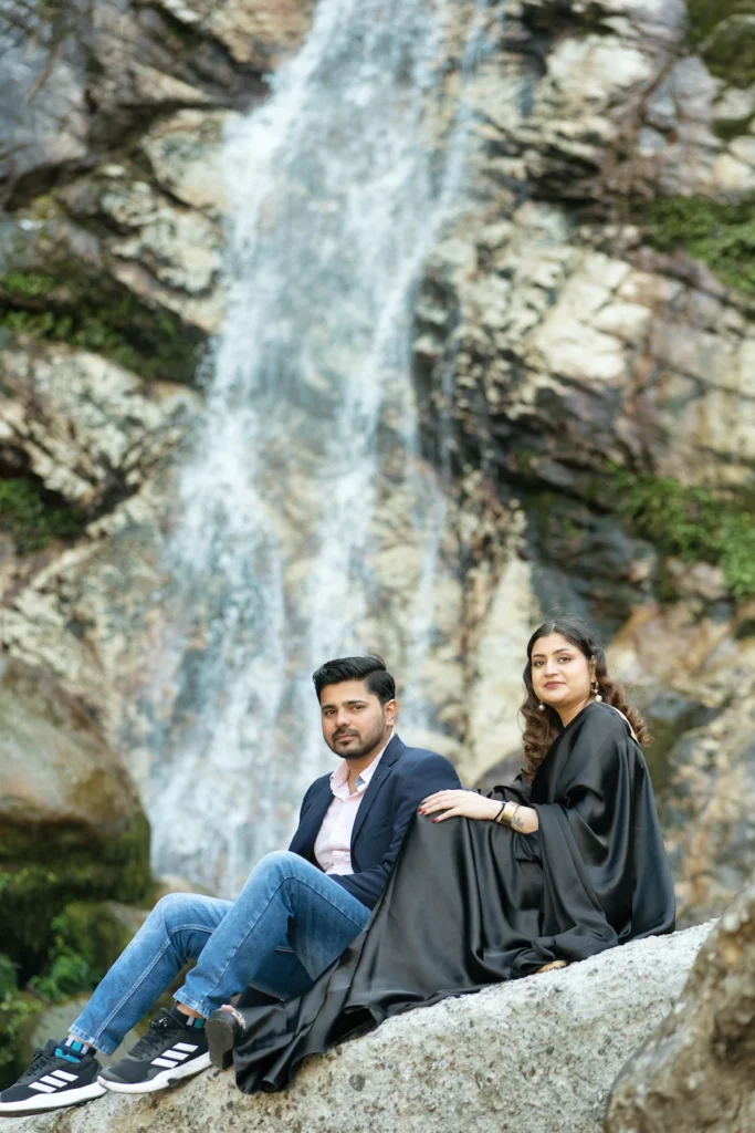 Couple posing near a waterfall during an outdoor pre-wedding shoot
