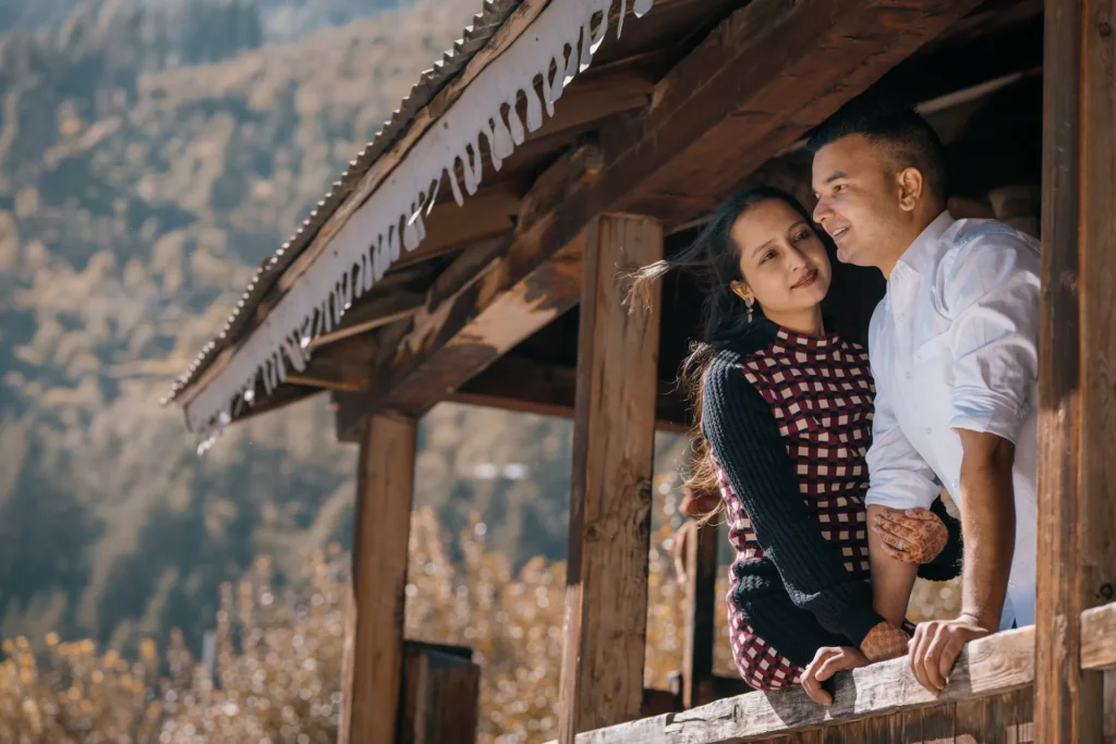 Couple posing in a traditional Himalayan village with snow-capped mountains