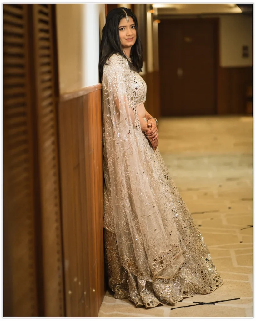 Bride leaning against a corridor wall during an elegant indoor engagement portrait session.