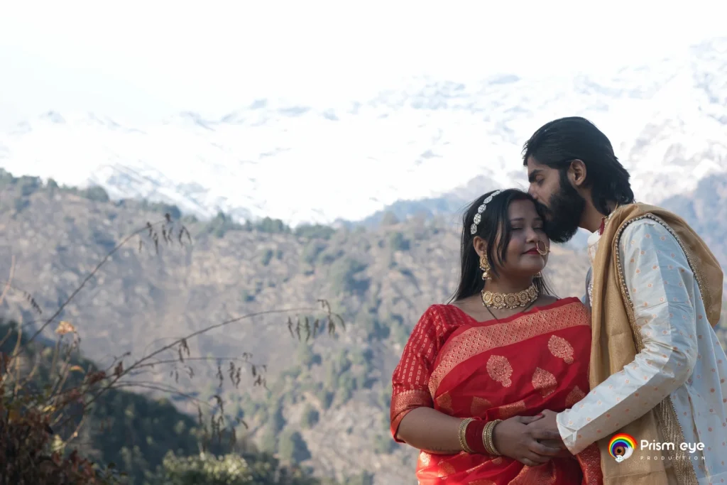 Bride and groom embracing with the snow-capped Himalayan mountains in the background.