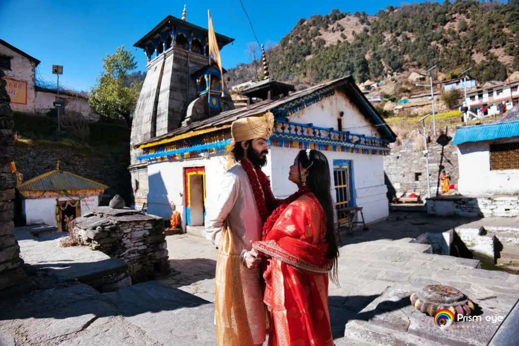Bride and groom standing outside the sacred Kedarnath Temple during their traditional ceremony.