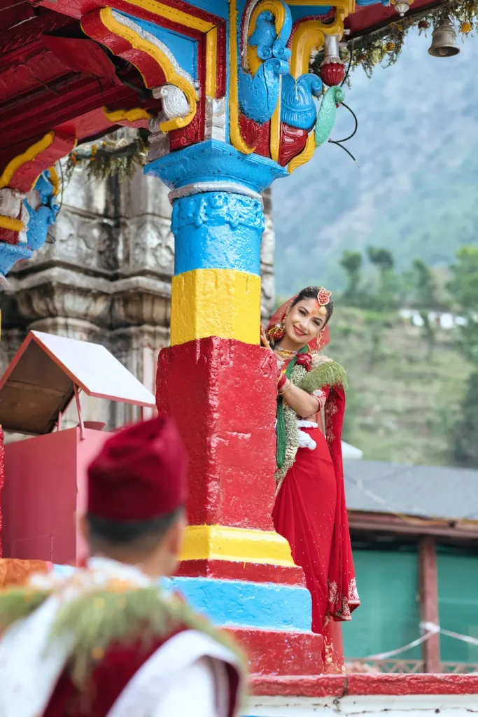 Bride posing at Omkareshwar Temple during a Ukhimath wedding, surrounded by vibrant temple architecture and Himalayan wedding traditions.
