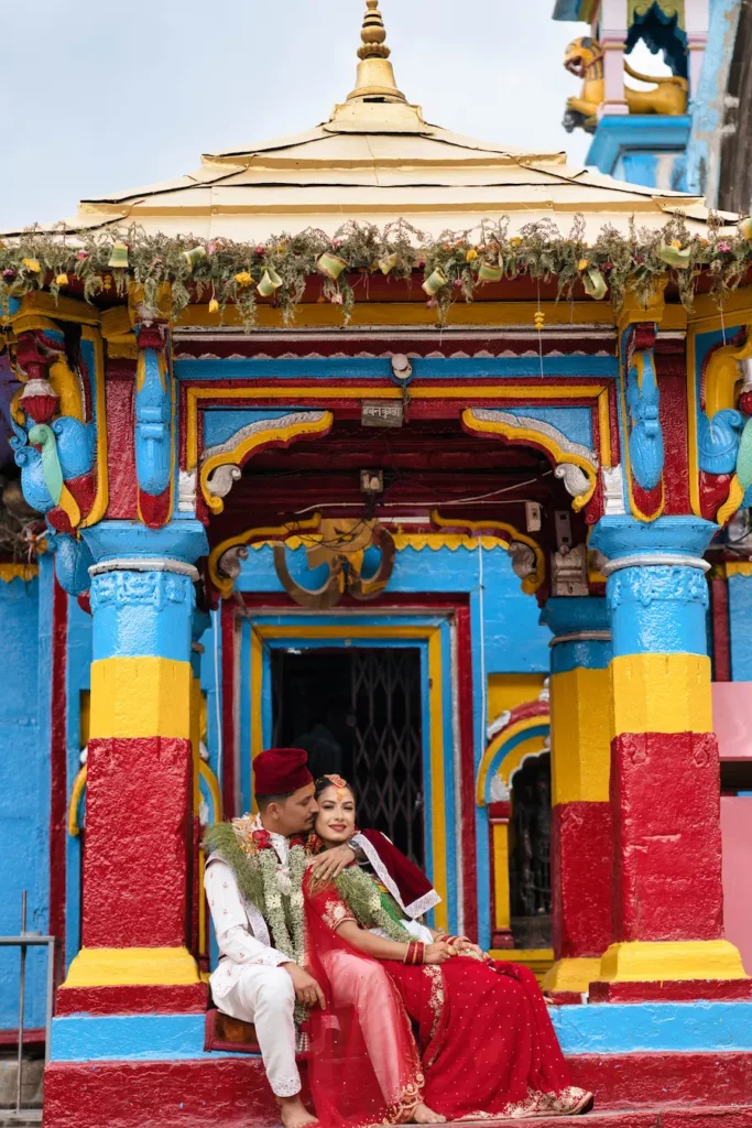 Romantic couple portrait from a Ukhimath wedding, featuring traditional attire and colorful temple architecture in Uttarakhand.