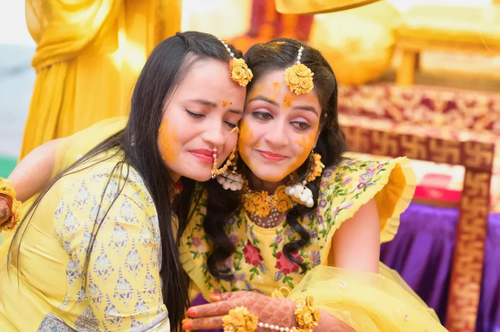 Family member lovingly applying Haldi to the bride during the pre-wedding ceremony.