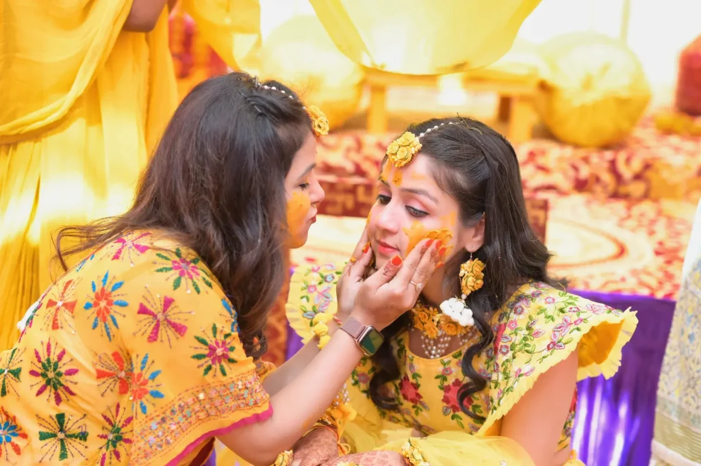 Wedding Haldi ceremony with family applying turmeric to the bride during a joyful pre-wedding celebration.
