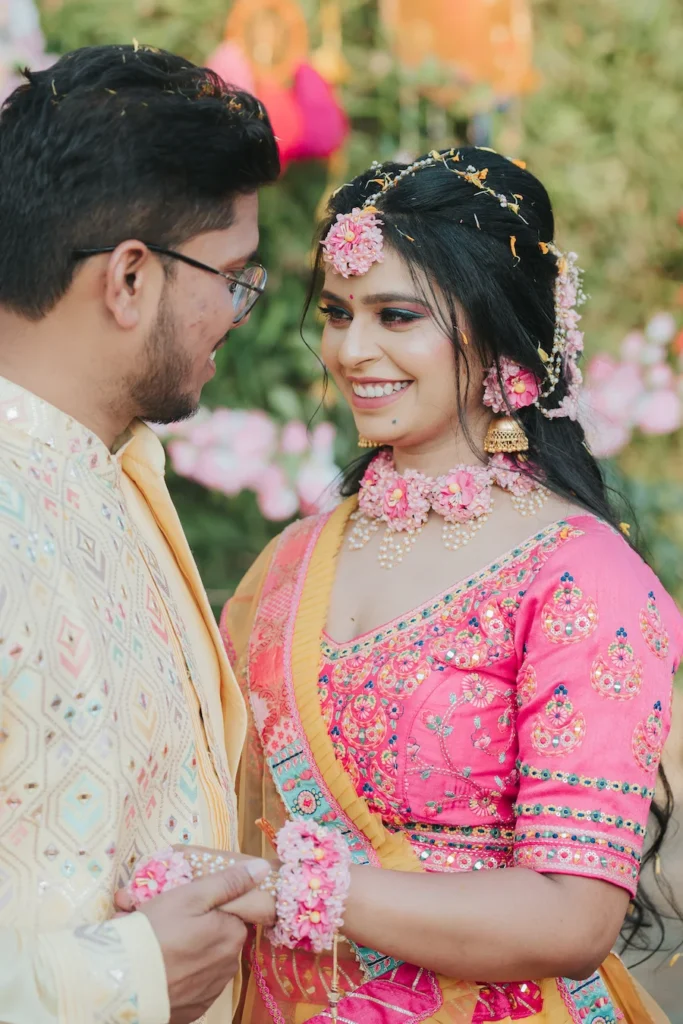 Smiling couple sharing candid moments during traditional haldi festivities