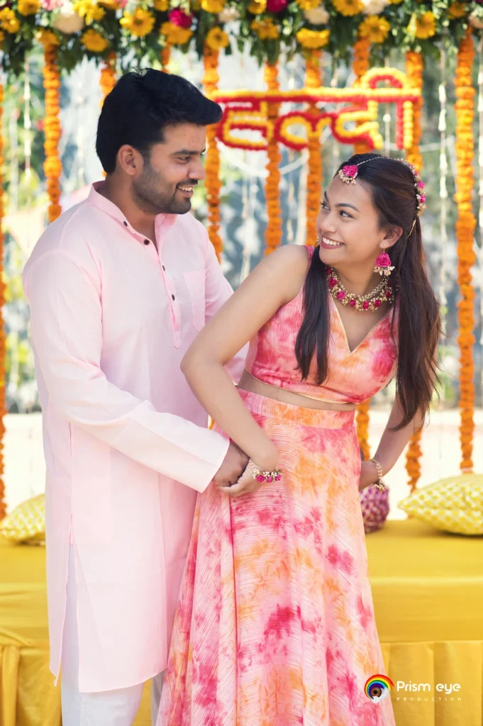 Candid haldi ceremony couple portrait with floral jewellery and joyful wedding moments