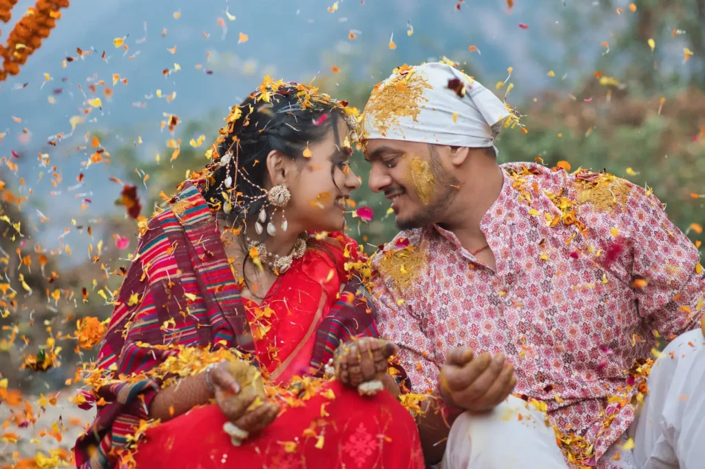 Bride and groom celebrating with flower petals during a traditional Hindu wedding ritual.