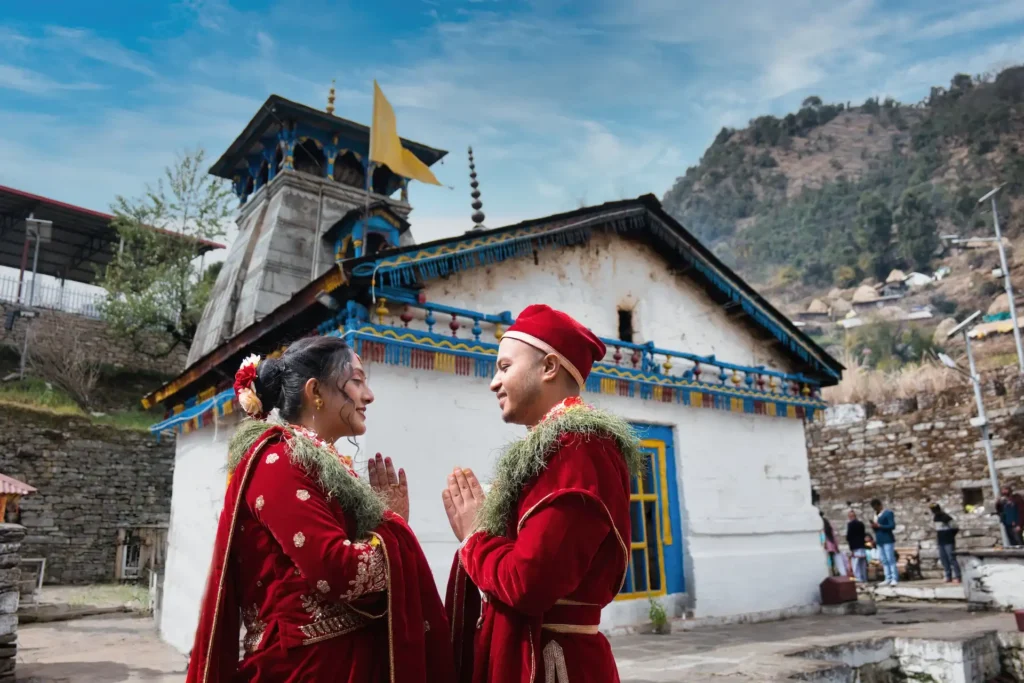 Destination wedding couple portrait outside Triyuginarayan Temple with scenic Himalayan mountain backdrop in Uttarakhand