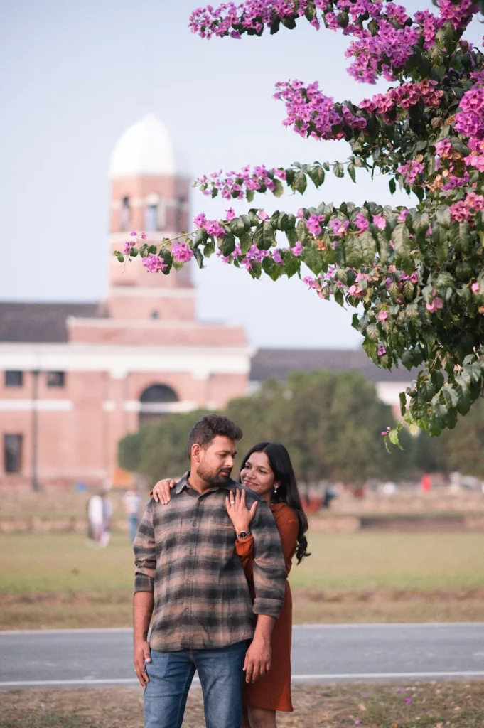 Couple portrait beneath blooming flowers during the best time for pre-wedding shoot in Dehradun