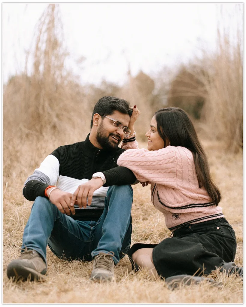 Couple sharing a playful moment in a meadow during the best time for pre-wedding shoot in Dehradun