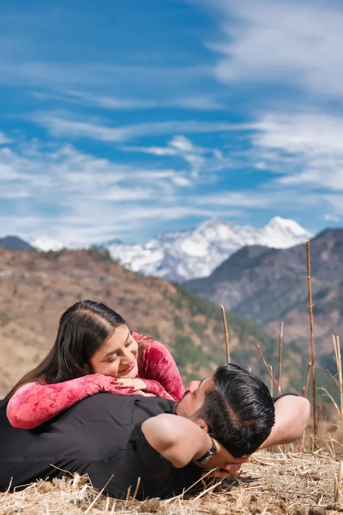 Romantic couple enjoying a candid moment with scenic Himalayan mountains in the background during an outdoor pre wedding photoshoot.