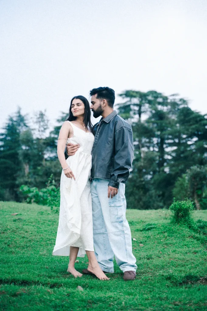 Elegant couple portrait in an open meadow surrounded by lush greenery during a destination pre wedding photoshoot.