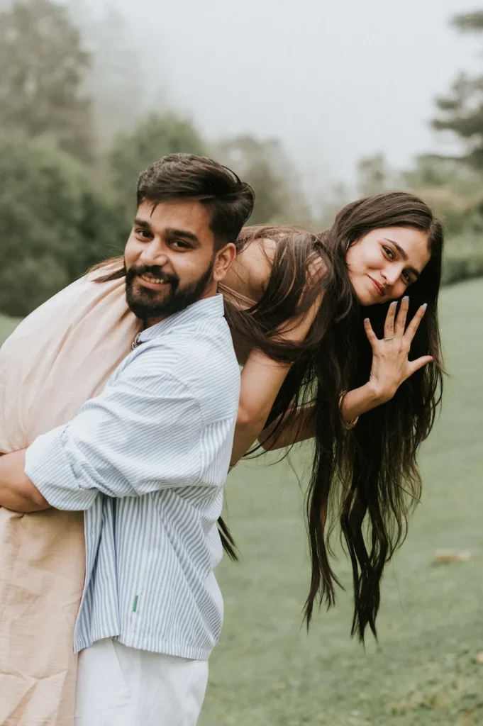Pre-Wedding Photoshoot Trends 2026 featuring a playful couple pose with candid emotions in a natural outdoor setting.