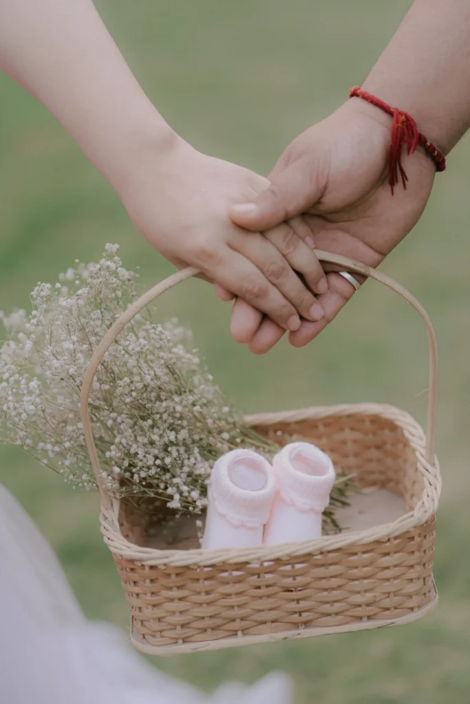 Expecting parents holding baby shoes during a pregnancy photoshoot