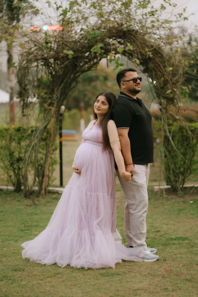 Elegant maternity portrait of expecting parents in a garden setting