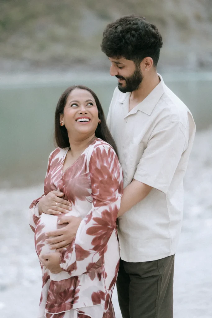 Romantic outdoor portrait of expecting parents by the riverside