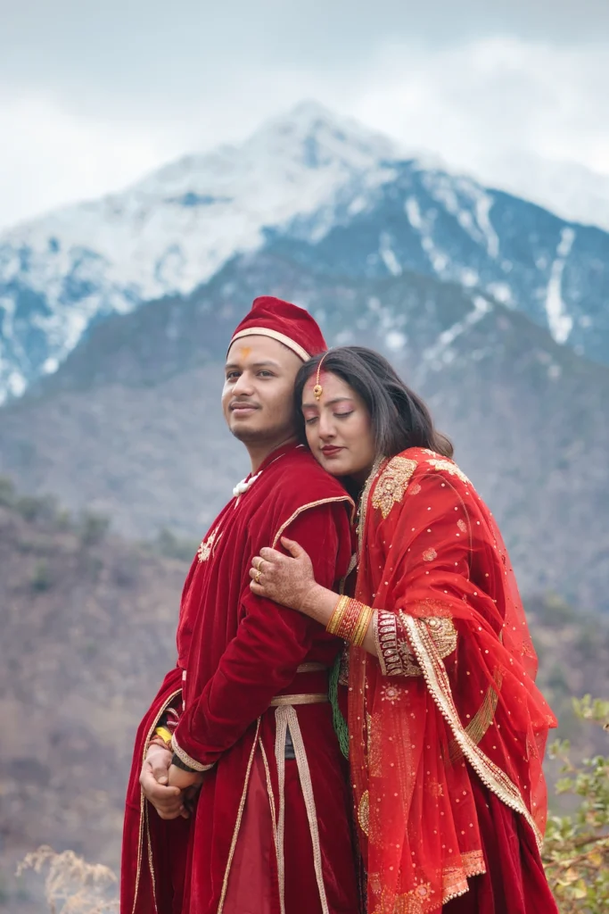 Bride and groom posing together with majestic snow-capped mountains in the background