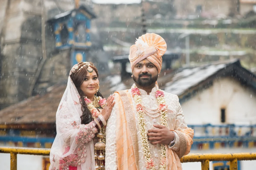 Bride and groom posing together during a traditional wedding ceremony with a heritage backdrop